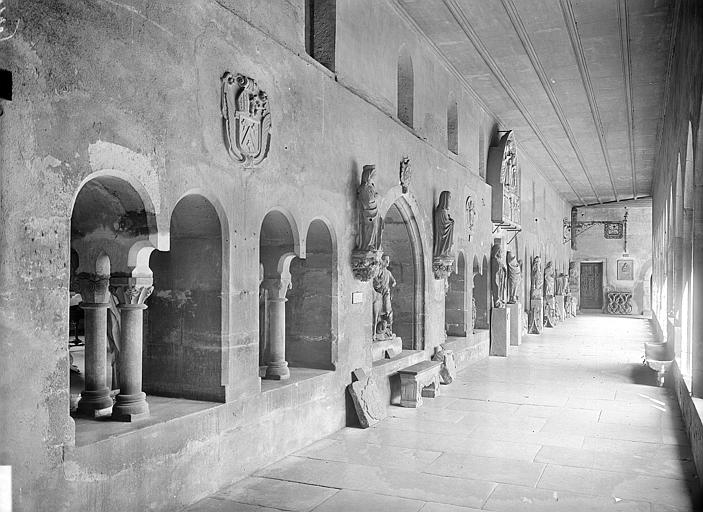 Vue intérieure de la galerie sud du cloître donnant sur l'église. Sculptures