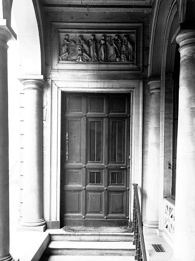 Porte sous une galerie d'arcades, surmontée d'un bas-relief sculpté (scène à l'antique)