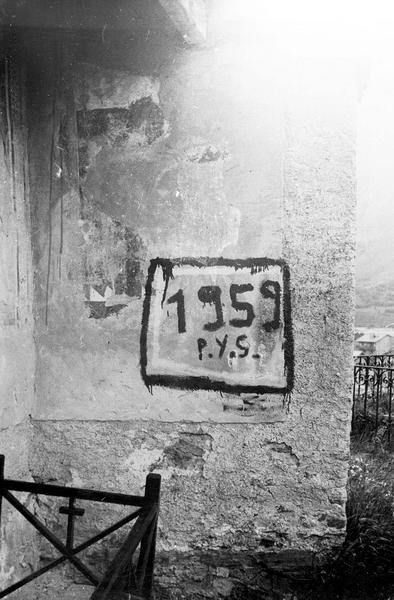 Inscription portée à la peinture noire sur un mur extérieur de l'église