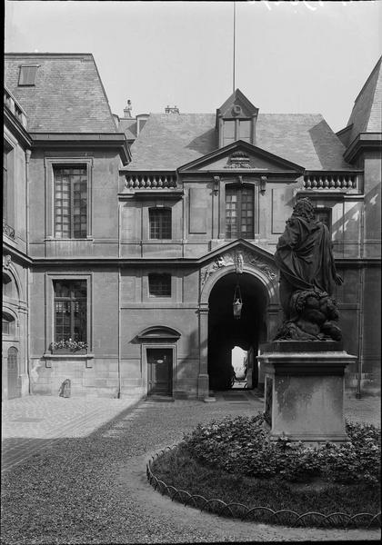 Cour intérieure : façade avec le bas-relief des Génies au-dessus de la porte