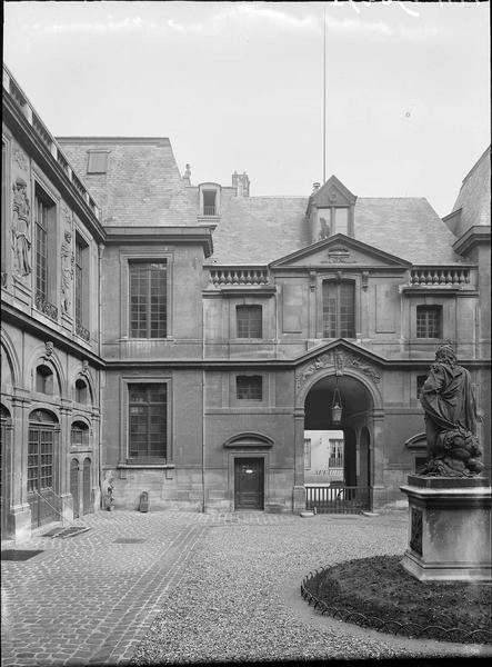 Cour intérieure : façade avec le bas-relief des Génies au-dessus de la porte