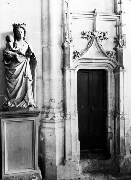 Porte de la sacristie et statue en pierre de la Vierge à l'Enfant