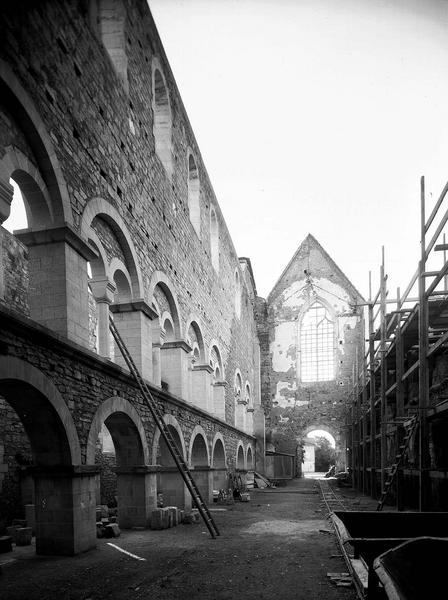 Vue intérieure de la nef vers l'ouest : élévation des grandes arcades et du mur sud