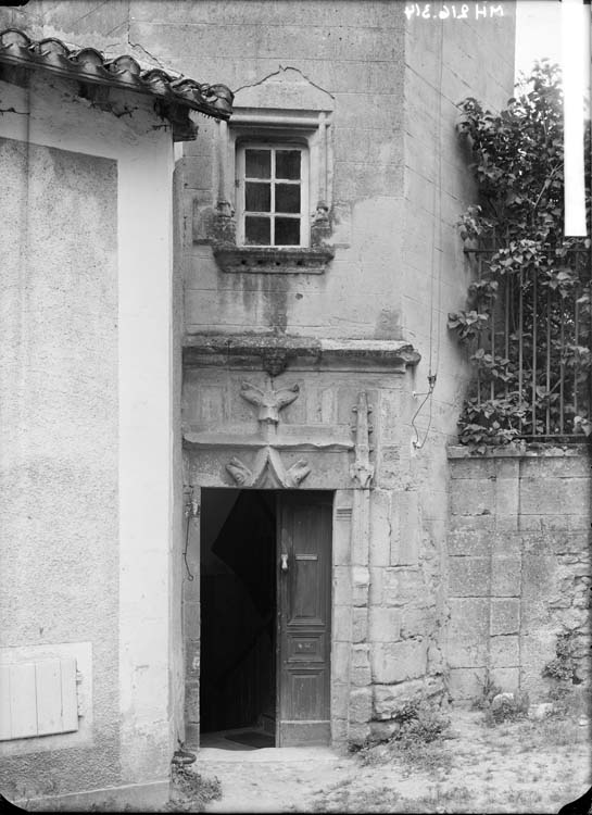 Porche d'une tourelle hexagonale renfermant un escalier à vis : motif de têtes de poissons