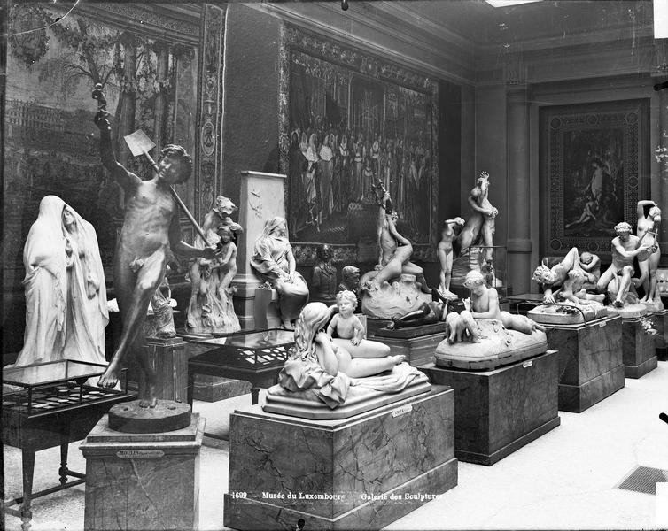 Galerie de Sculpture, vers 1912 : vue partielle, avec au premier plan « Une trouvaille à Pompéï » d'Hippolyte Moulin (1863) et « La Jeunesse et l'Amour » de Gustave Craux (salon de 1884)