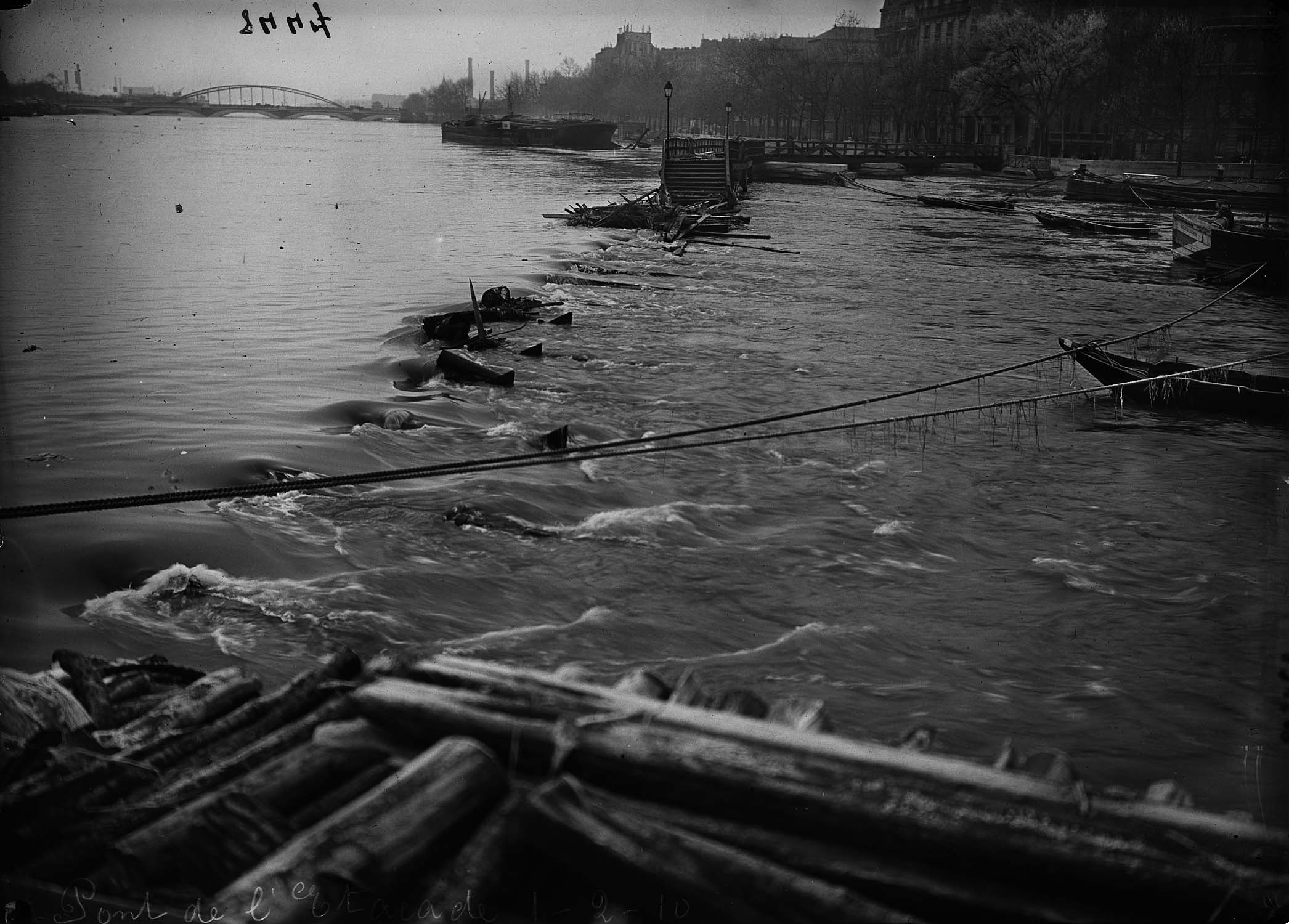 Péniche et jetée sur la Seine en crue en aval du pont