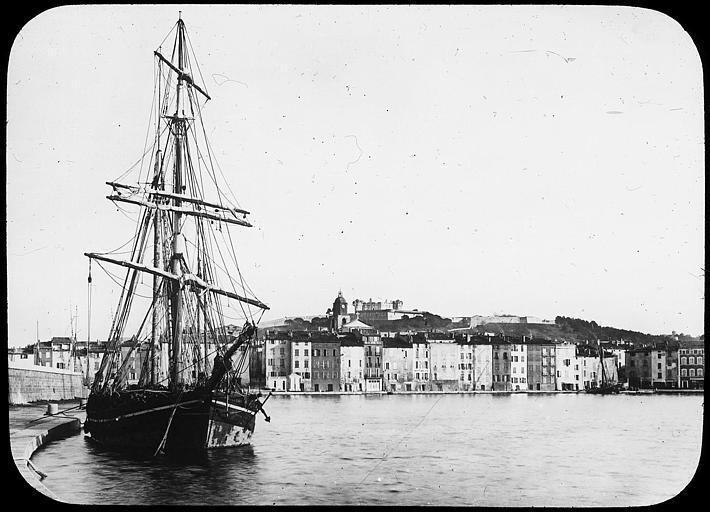 Vue générale du port et de la ville ; au premier plan, un voilier