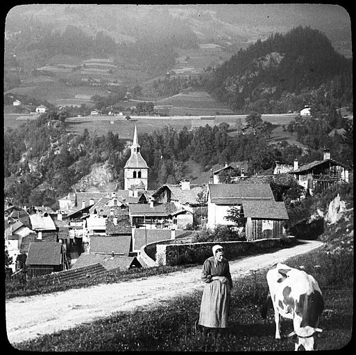 Vue générale ; au premier plan, une paysanne et sa vache