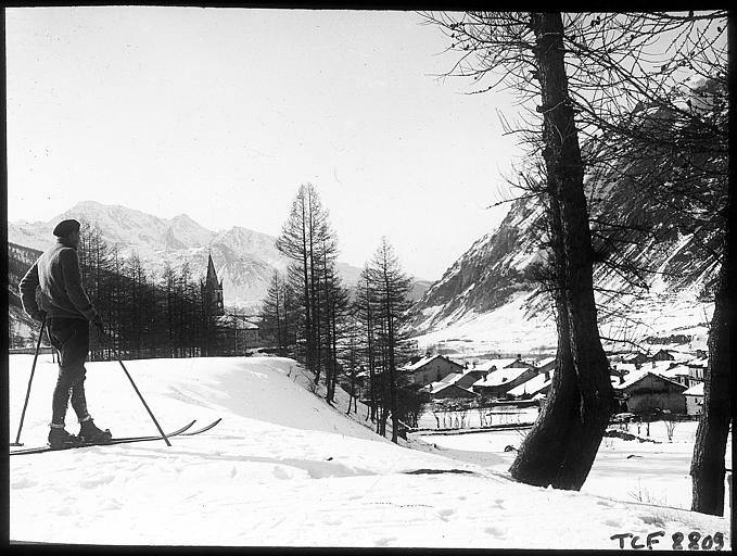 Skieur à l'entrée du village ; au lointain, le Mont-Cenis
