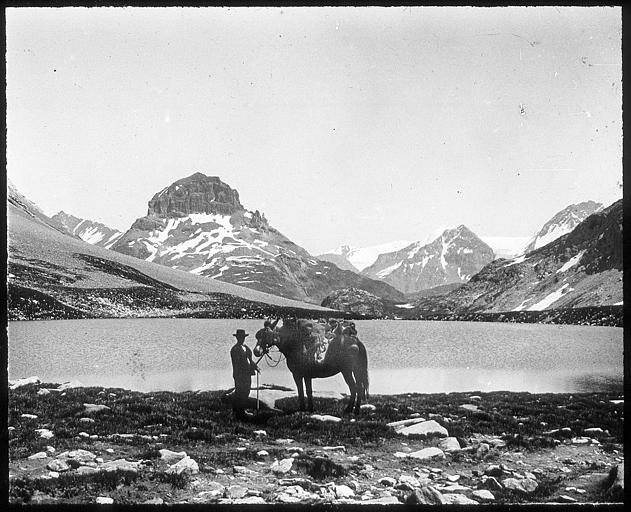 Sur les bords du lac Rond, un homme et son cheval ; massif de la Vanoise