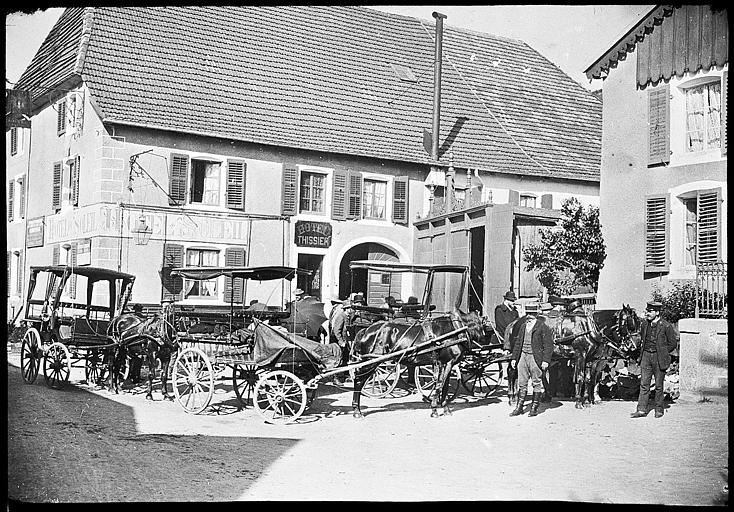 Voitures à cheval rassemblées devant la porte