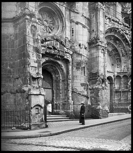 Jeune femme devant le portail latéral de la façade principale