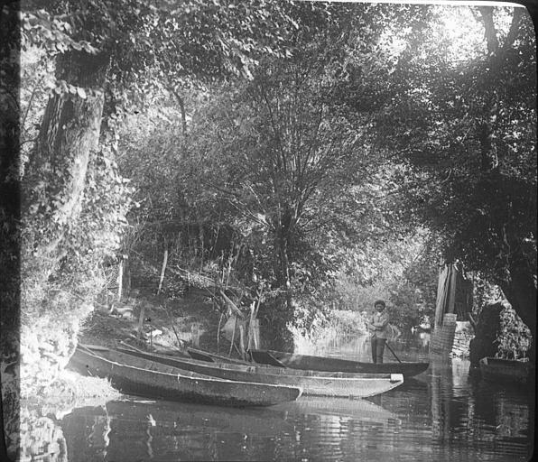 Sur une route d'eau, paysan debout dans sa barque