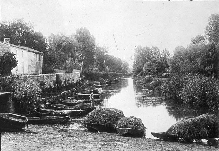 Gamins pêchant debout sur des barques à l'amarre