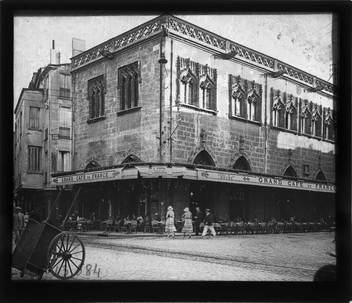 Façade sur rue animée avec terrasse du Grand café de France au rez-de-chaussée