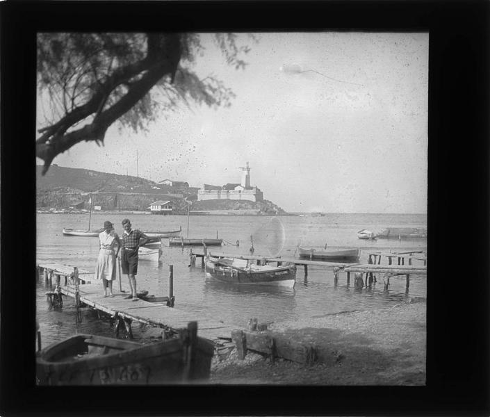 Barques amarrées dans l'anse Cristine, entrée du port et phare en arrière-plan, vue animée