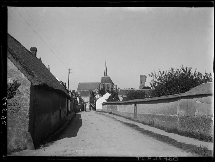 Perspective sur l’église et les restes de la tour, prise depuis une rue