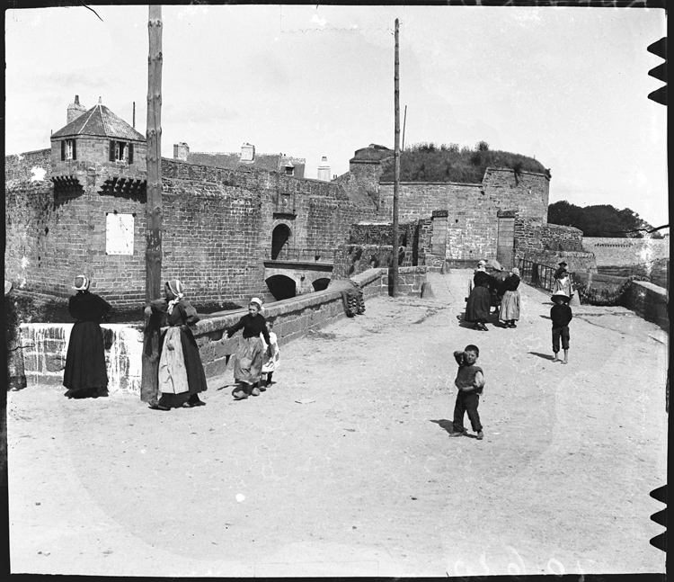 Passants sur la digue menant à la ville close