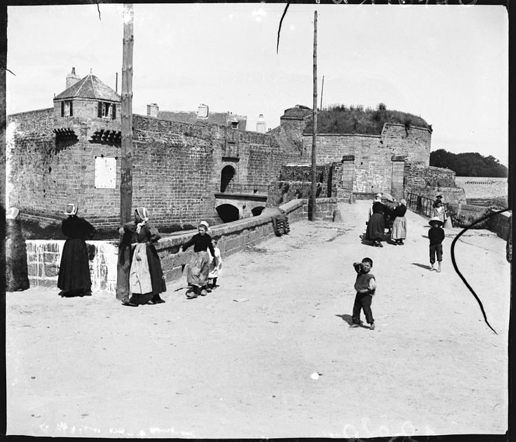 Passants sur la digue menant à la ville close