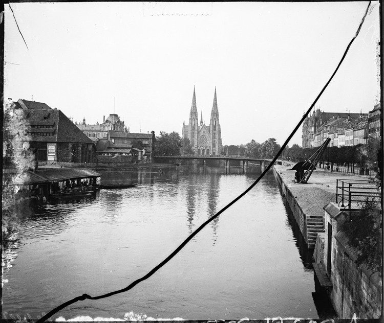 Perspective sur la façade occidentale prise depuis un pont sur l’Ill