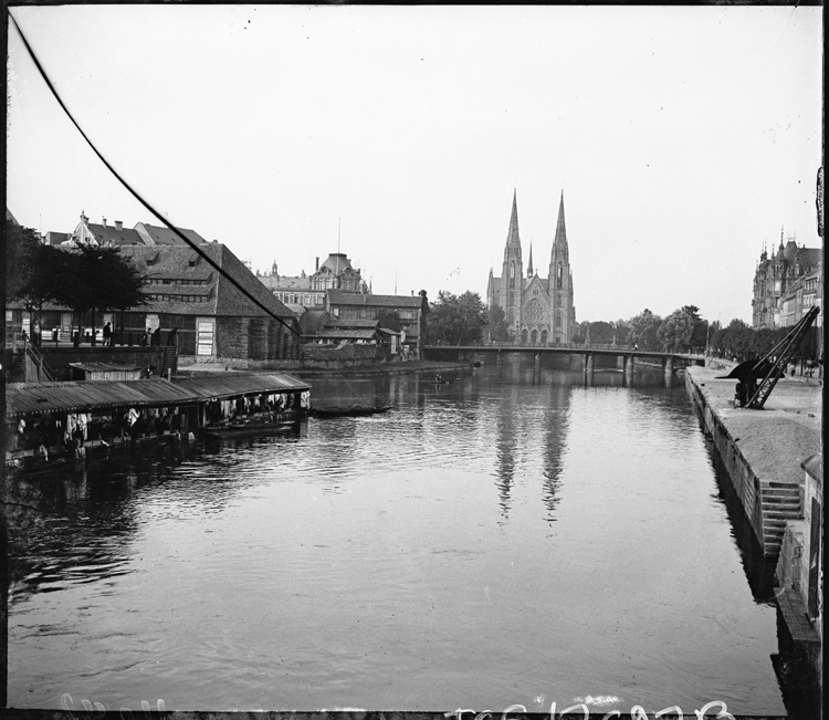 Perspective sur la façade occidentale prise depuis un pont sur l’Ill