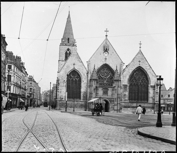 Façade ouest de l’église, un marchand ambulant installé sur la place