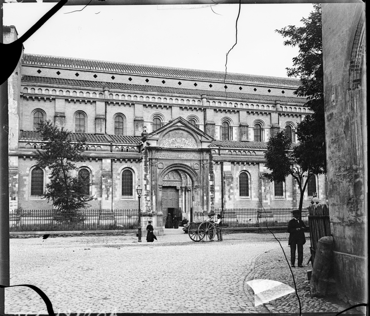 Charrette et passants devant la porte Bachelier