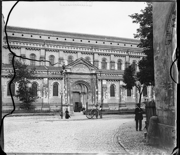 Charrette et passants devant la porte Bachelier