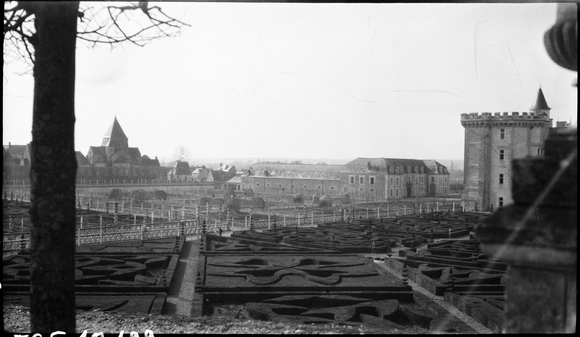 Vue sur le château, les parterres de charmilles et le village, dont l’église Saint-Étienne