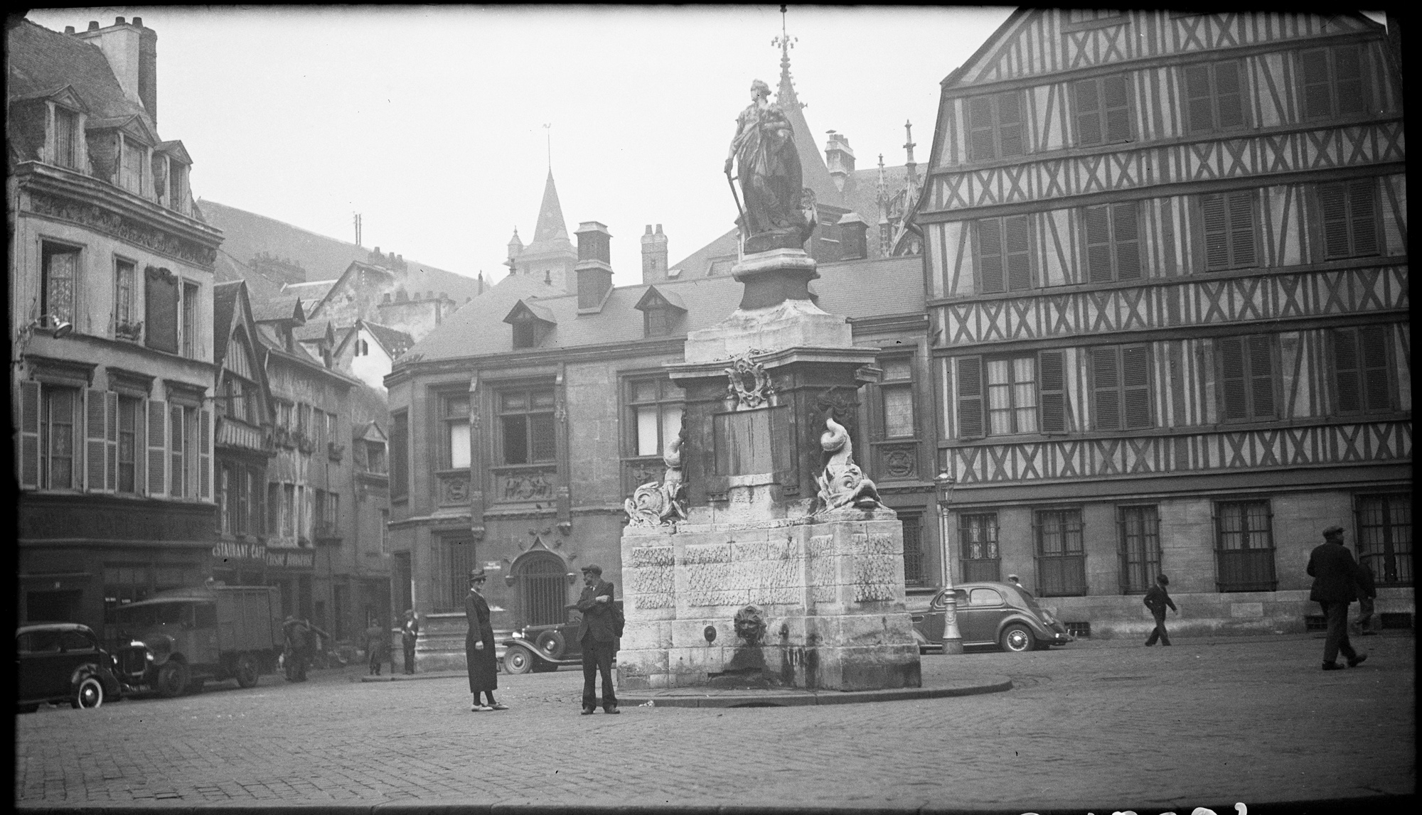 Promeneurs autour de la fontaine Jeanne-d’Arc, l’hôtel de Bourgtheroulde à l’arrière-plan