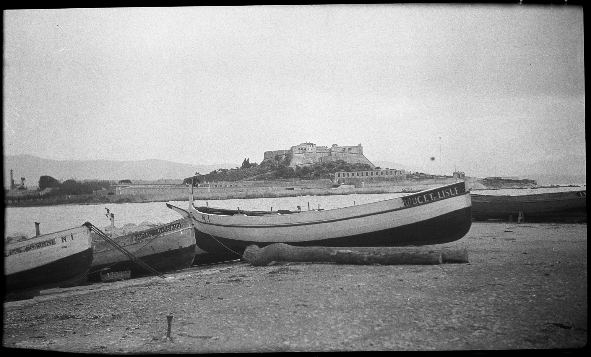 Le fort vu de la plage, des barques amarrées au premier plan