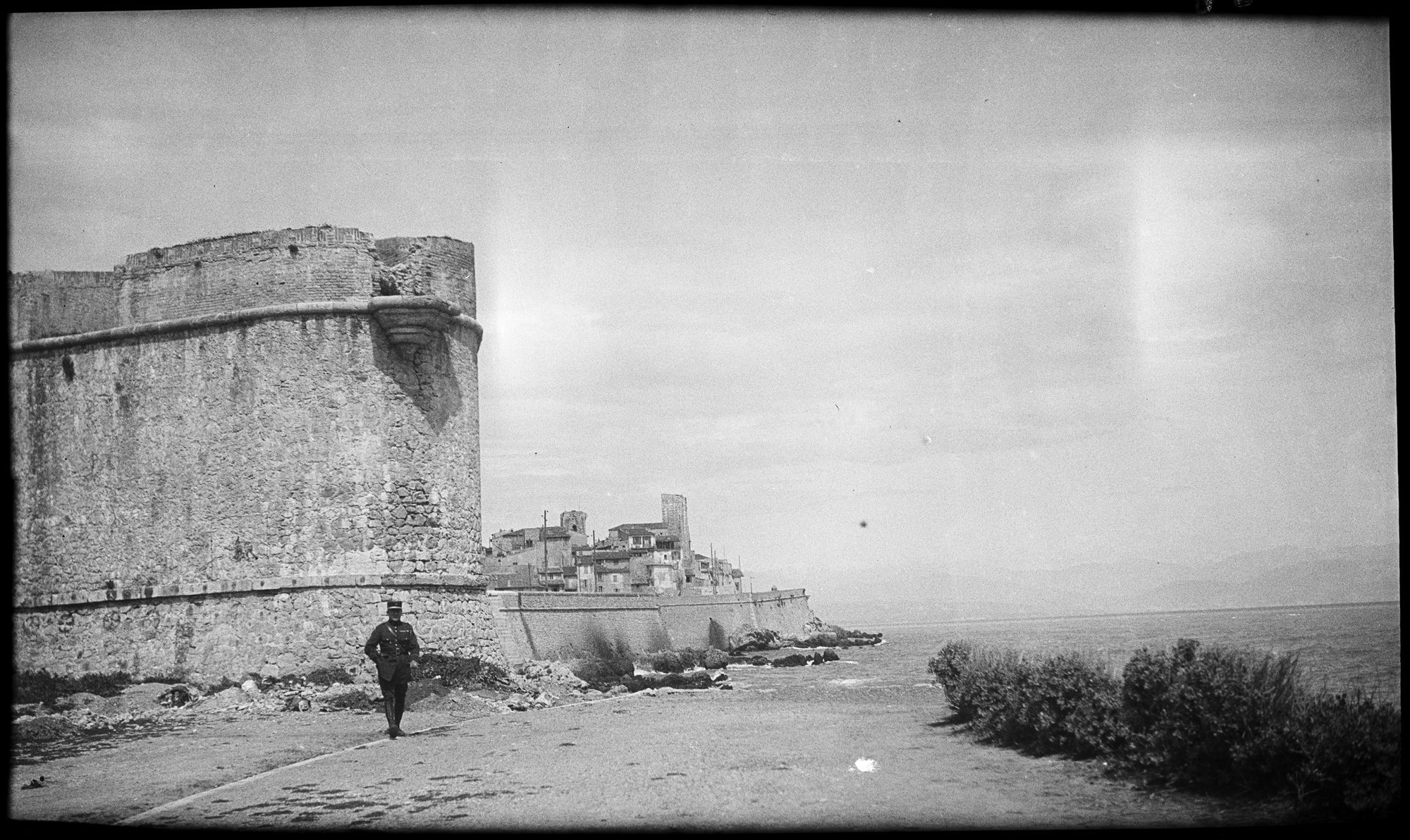 Militaire posant des fortifications en bord de mer, peut-être le fort carré d’Antibes