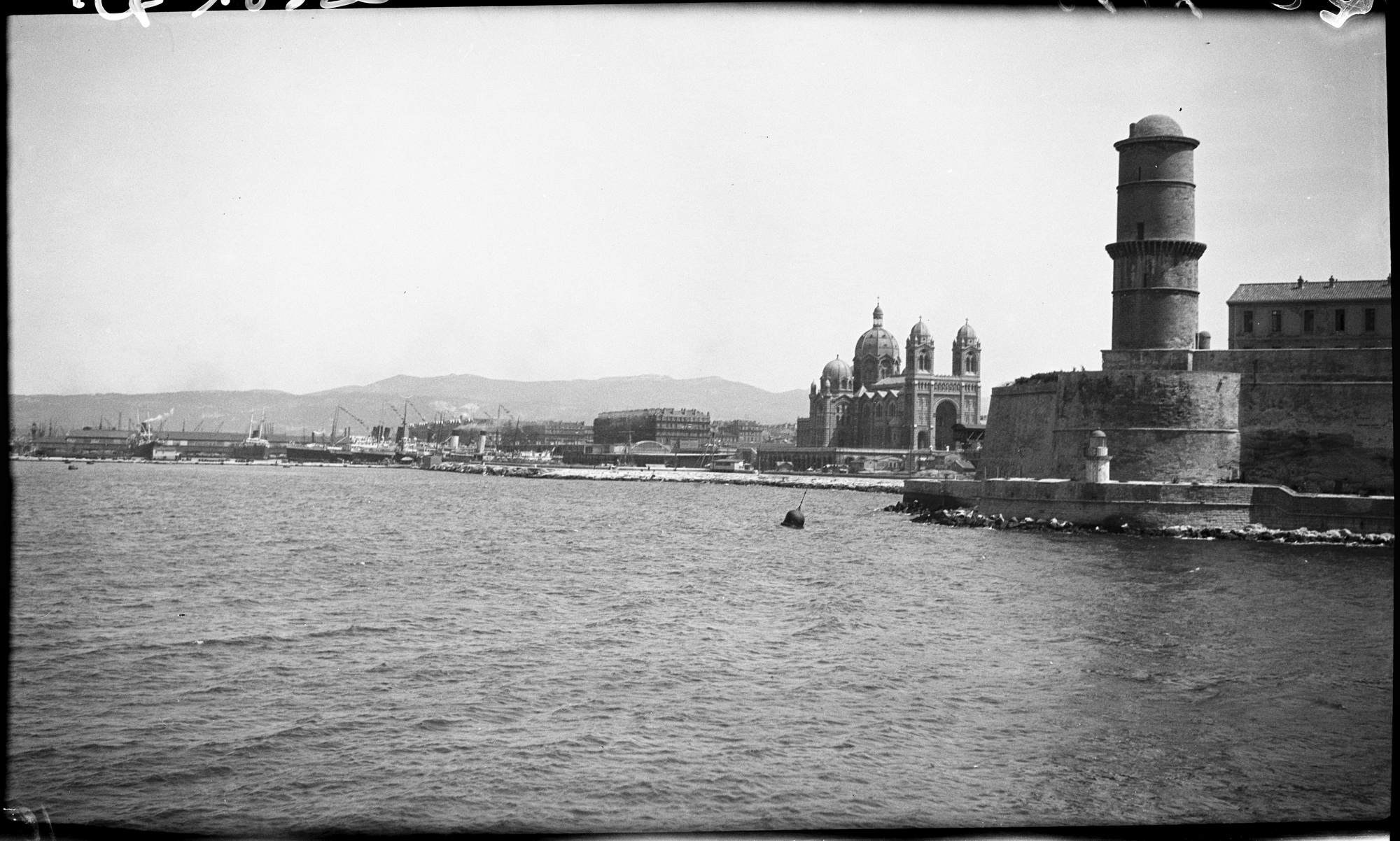 Front de mer marseillais vu depuis la mer, la tour du fanal au premier plan, les dômes et tours de la cathédrale à l’arrière