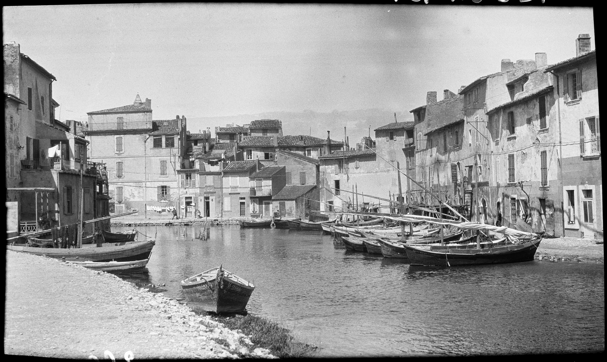 Village le long d’un canal et barques amarrées