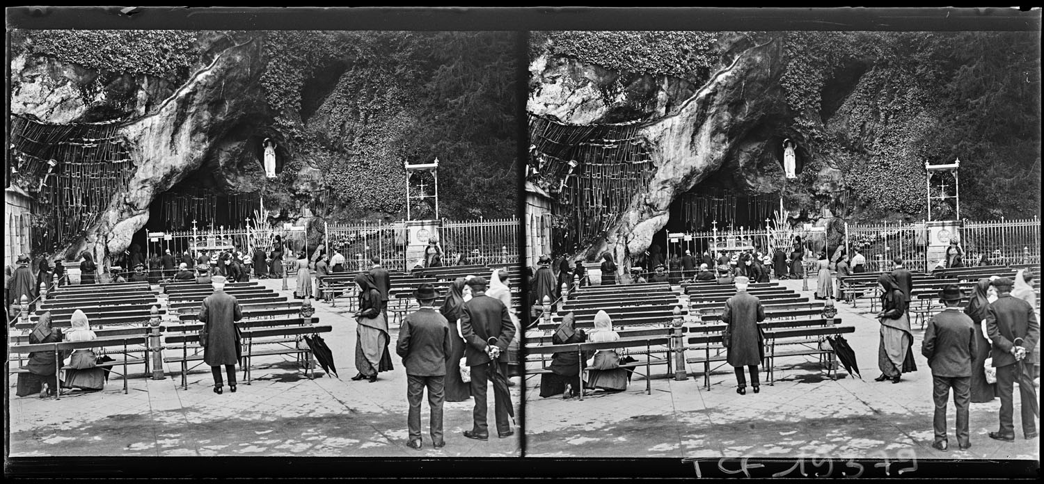 Pèlerins priant devant la grotte