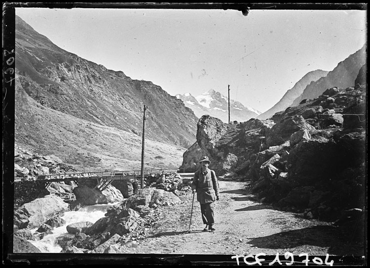 Promeneur longeant une rivière, dans un paysage de montagne