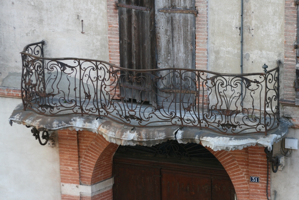 Balcon en arbalète au garde-corps de fer forgé de style Louis XV.