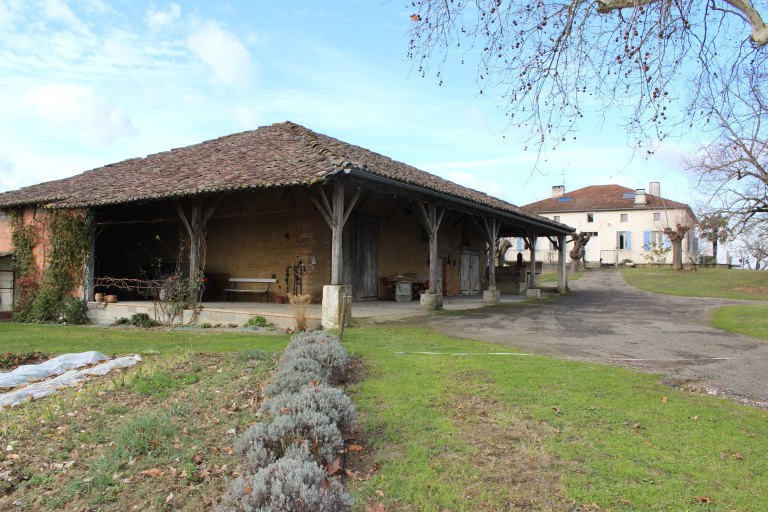 Vue de la grange-étable et du logis, en arrière plan.