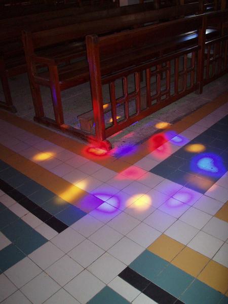 Taches de lumière des vitraux sur les carrelages.