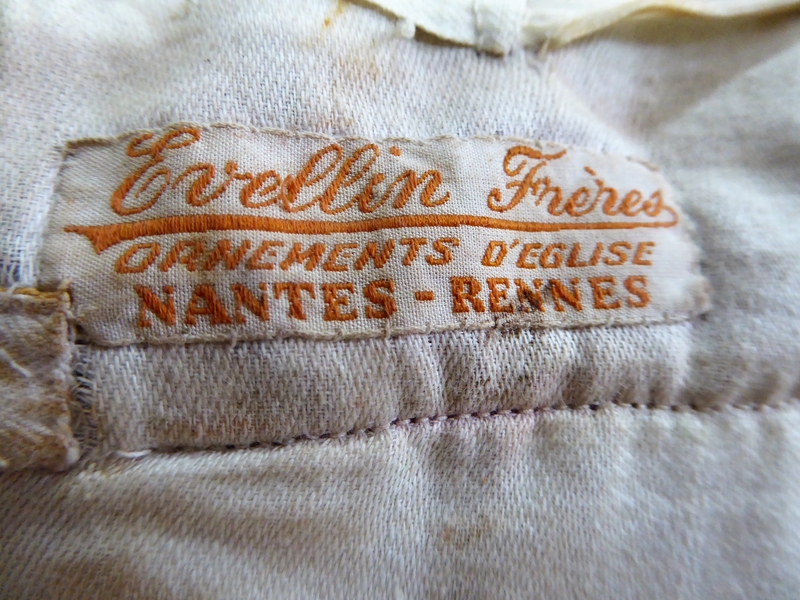 Revers : marque de fabricant brodée sur une étiquette au bord de la doublure « ÉVELLIN FRÈRES / ORNEMENTS D'ÉGLISE / NANTES-RENNES ».