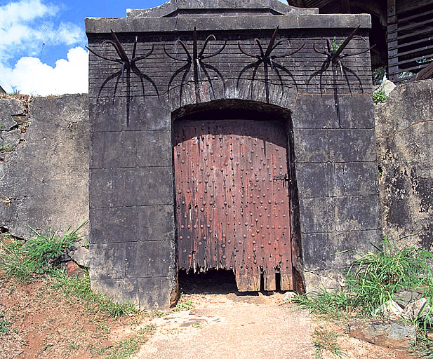 L'entrée nord du poste de garde, vue extérieure. Porte légèrement cintrée en bois renforcée par des clous.