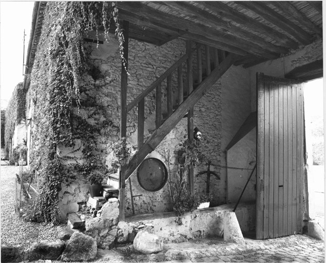 Vue du passage d'entrée situé dans le bâtiment des étables avec l'escalier d'accès au fenil qui surmonte celui-ci.