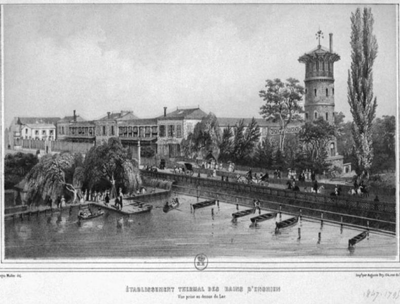 Vue d'ensemble de l'établissement thermal d'Enghien 'prise au dessus du lac'. Au premier plan, la tour réservoir dans sa deuxième version de 1864 est reliée par une passerelle au bâtiment de soins.