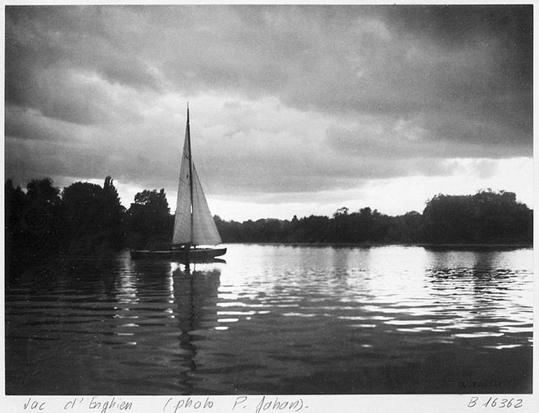 Vue du lac d'Enghien avec un voilier.