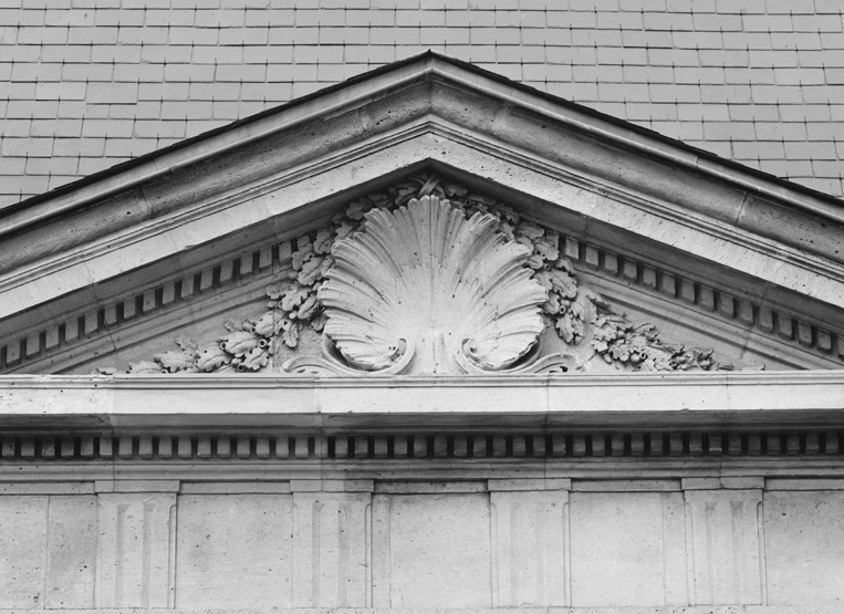 Vue partielle du fronton d'un pavillon d'entrée.