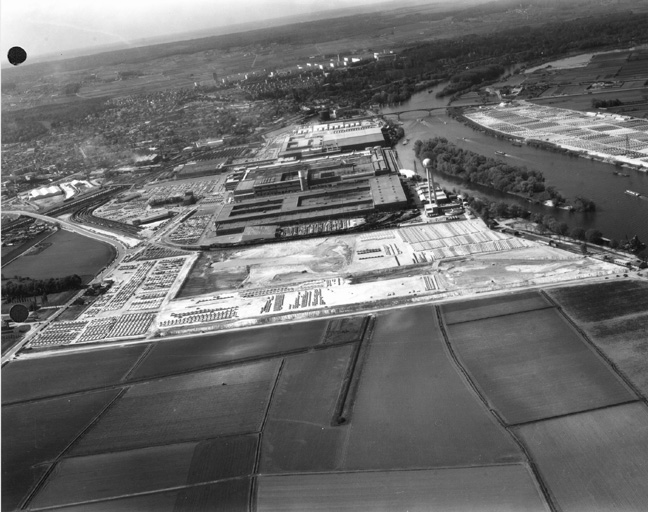 Vue aérienne de l'ensemble de l'usine : la totalité de l'usine Simca est construite ainsi que son nouveau château d'eau.