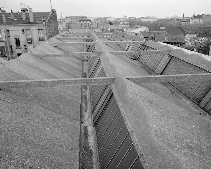 Vue des toitures des ateliers formées de sheds en béton armé.