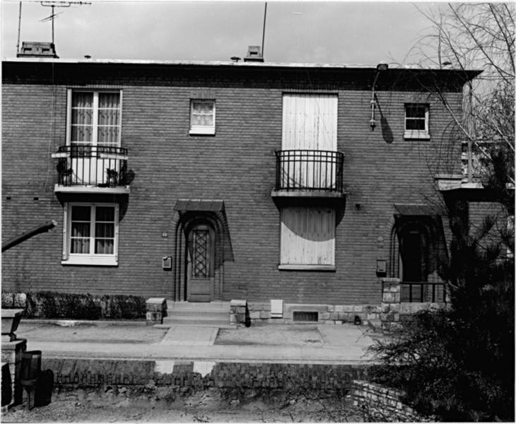 Cour et façades de maisons jumelles.