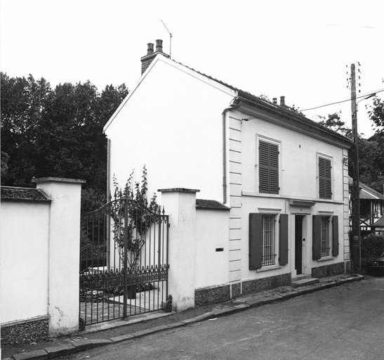 Vue de la façade antérieure et du portail en fer.