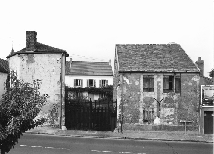 Vue d'ensemble avec le portail d'entrée et les bâtiments annexes en bord de rue et, en fond de cour, le logis.